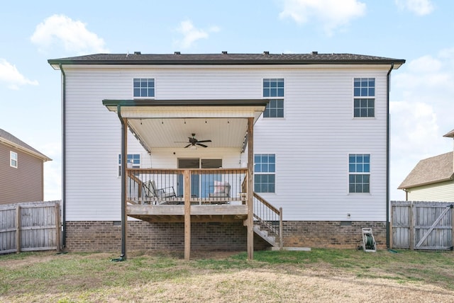 back of house with ceiling fan, a wooden deck, and a yard