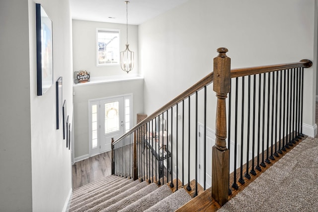 staircase featuring a chandelier and hardwood / wood-style floors