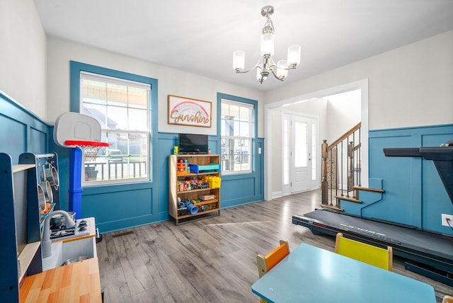 recreation room with a notable chandelier, a wealth of natural light, and hardwood / wood-style floors