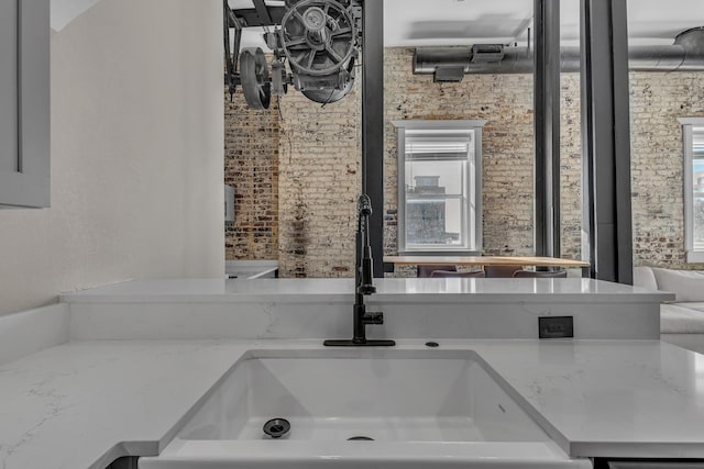 bathroom with sink and brick wall