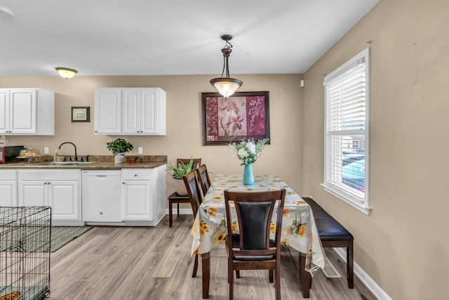 dining space with light hardwood / wood-style floors and sink