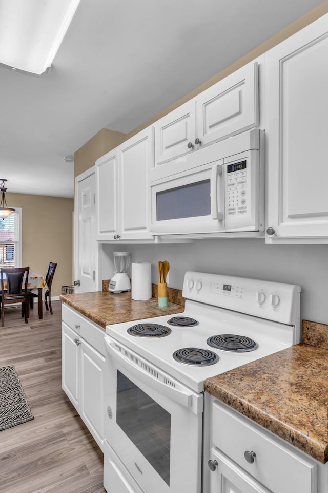 kitchen with white cabinetry, white appliances, and light hardwood / wood-style floors