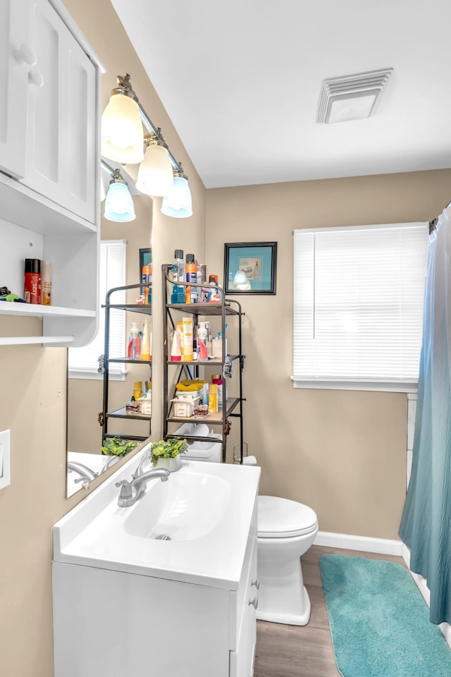 bathroom featuring vanity, hardwood / wood-style floors, and toilet