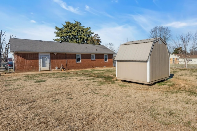 back of property with a yard and a storage shed