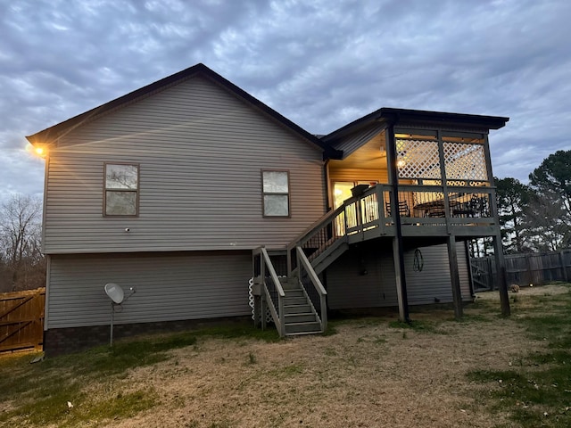 back of property featuring a deck and a lawn