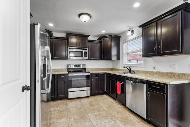 kitchen featuring dark brown cabinetry, sink, and appliances with stainless steel finishes