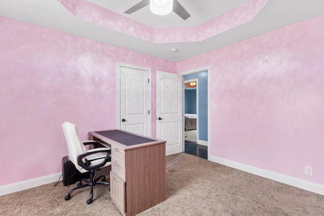 office area featuring ceiling fan, light colored carpet, and a raised ceiling