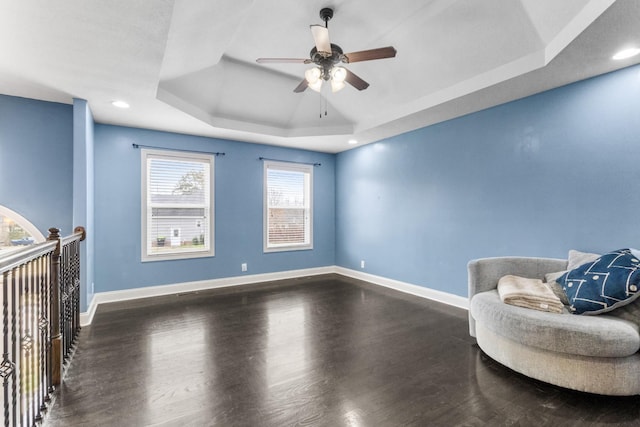 sitting room with a tray ceiling, ceiling fan, and hardwood / wood-style flooring