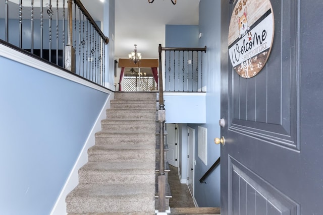 staircase with an inviting chandelier and a high ceiling