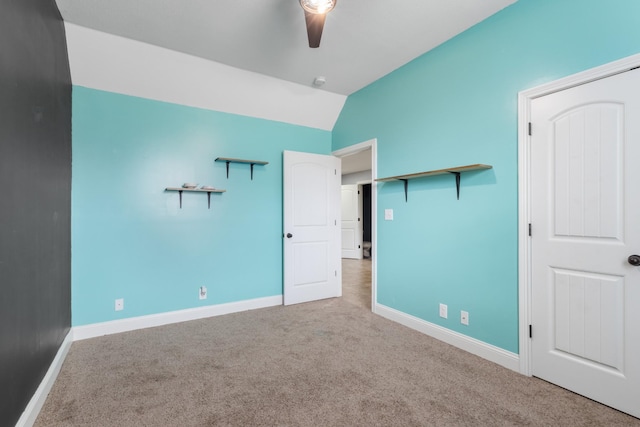 unfurnished bedroom with ceiling fan, lofted ceiling, and carpet floors