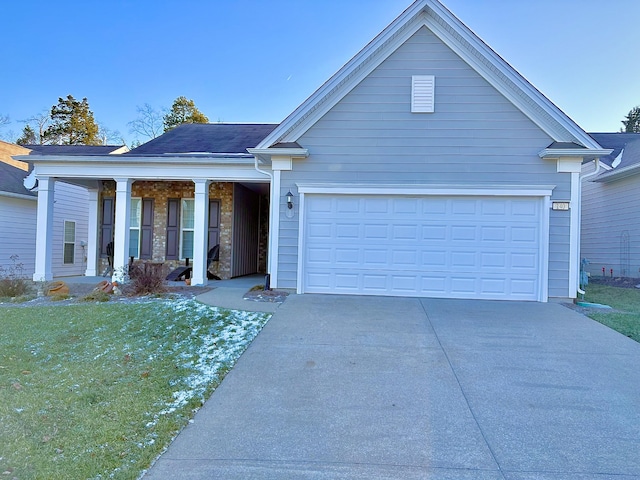 view of front of property with a garage, covered porch, and a front lawn