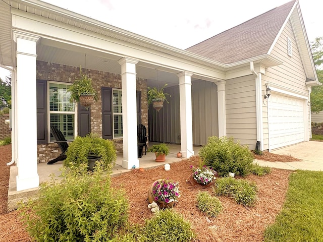 view of front of property with a porch, driveway, roof with shingles, and an attached garage