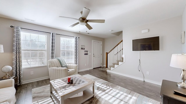 living room featuring ceiling fan and dark hardwood / wood-style flooring