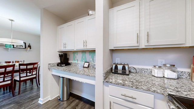 kitchen featuring decorative light fixtures, dark wood-type flooring, range, white cabinets, and light stone counters