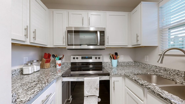 kitchen with white cabinets, light stone countertops, sink, and stainless steel appliances