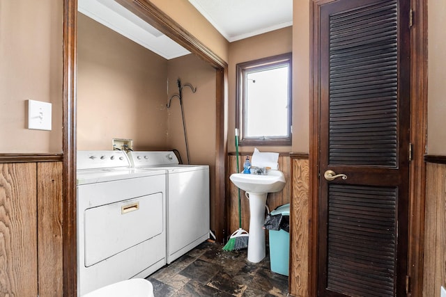 washroom featuring washer and dryer, crown molding, and wood walls