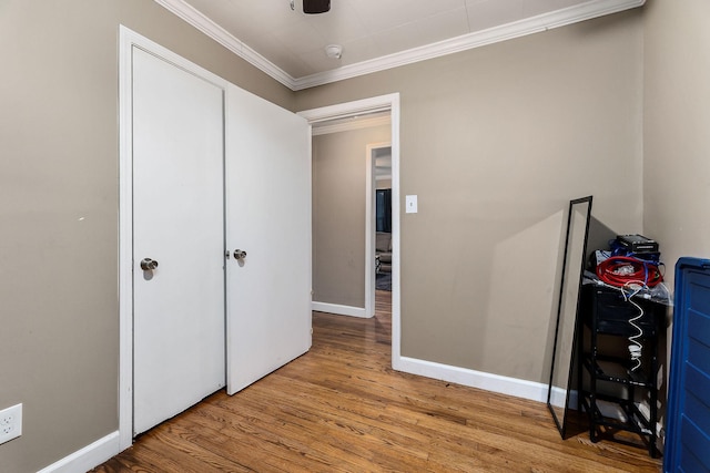 bedroom featuring ceiling fan, light wood-type flooring, and crown molding