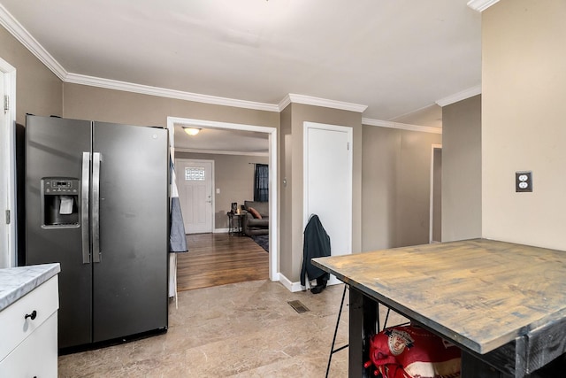 kitchen featuring white cabinetry, stainless steel fridge with ice dispenser, and crown molding