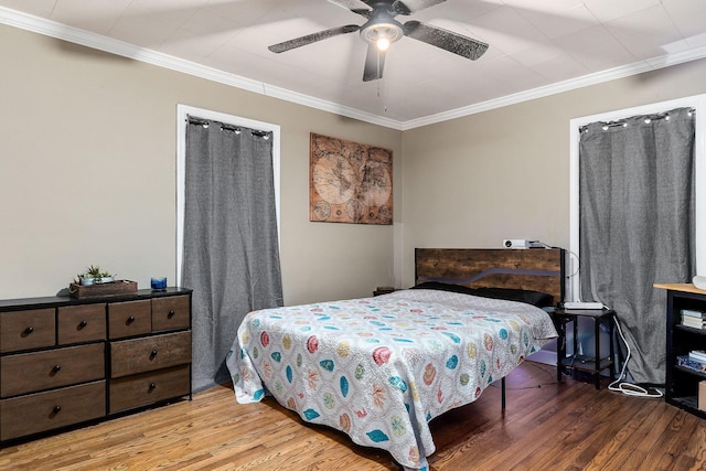 bedroom with ceiling fan, ornamental molding, and hardwood / wood-style floors