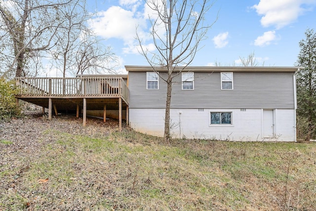 rear view of house with a lawn and a deck