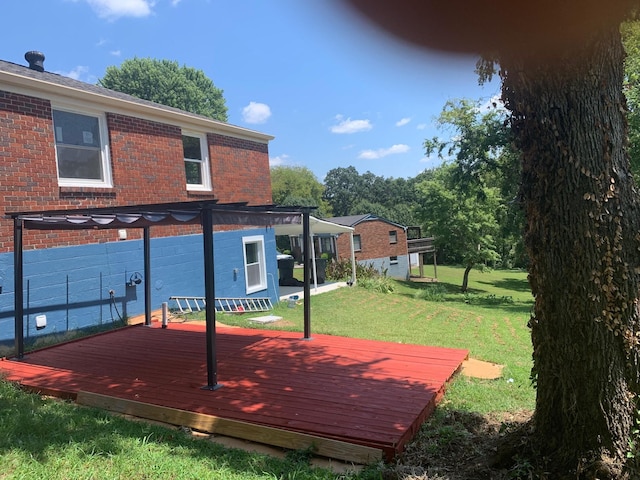 wooden deck featuring a yard and a pergola