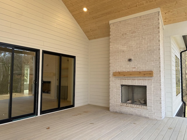 wooden deck with an outdoor brick fireplace