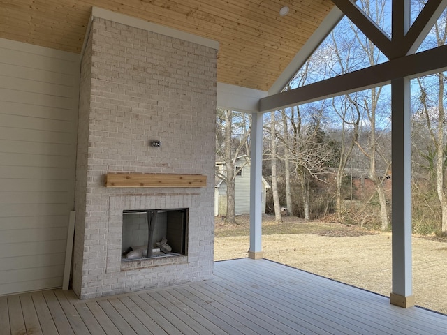 wooden deck with an outdoor brick fireplace