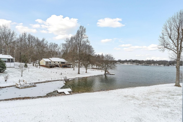 yard covered in snow featuring a water view