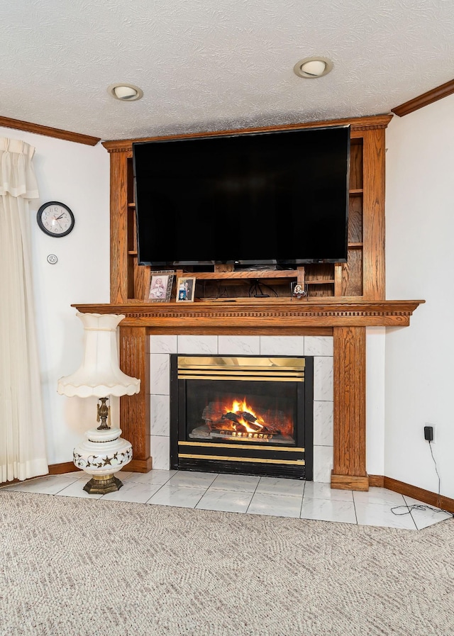 details with a tiled fireplace, a textured ceiling, and ornamental molding