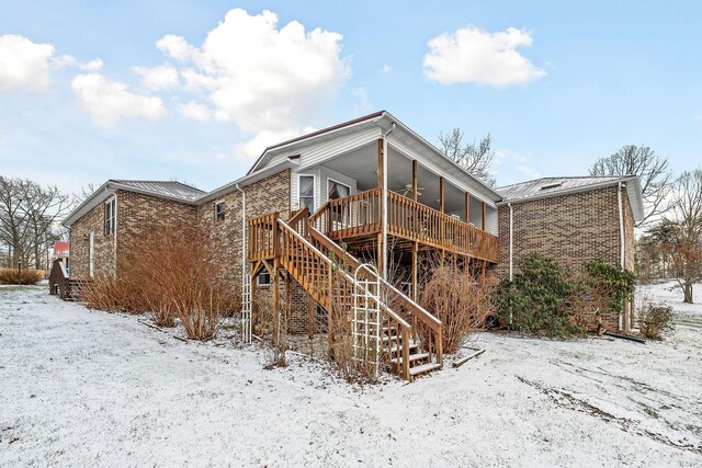 snow covered property featuring ceiling fan and a deck