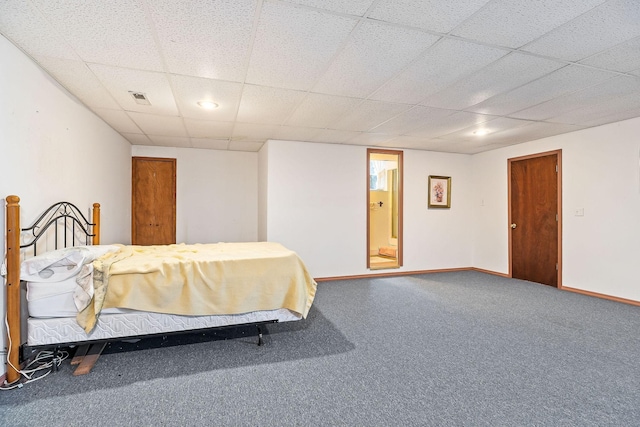 unfurnished bedroom featuring a paneled ceiling and carpet flooring