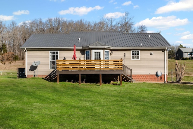 back of house featuring a lawn and a wooden deck