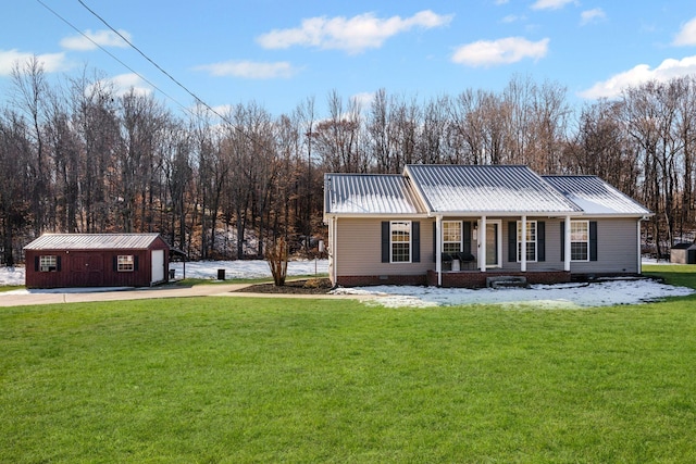 view of front facade with a porch, a garage, an outbuilding, and a front yard