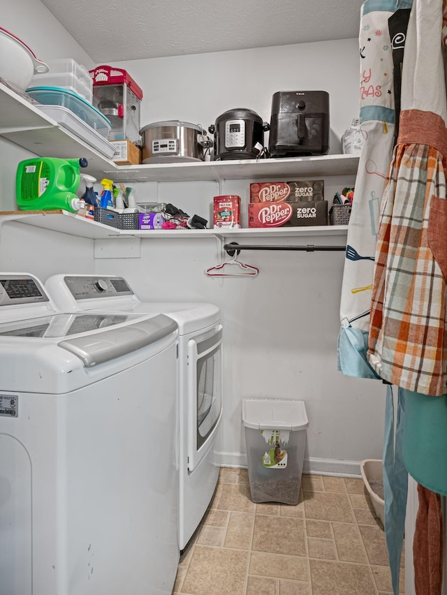 clothes washing area with washer and clothes dryer and a textured ceiling