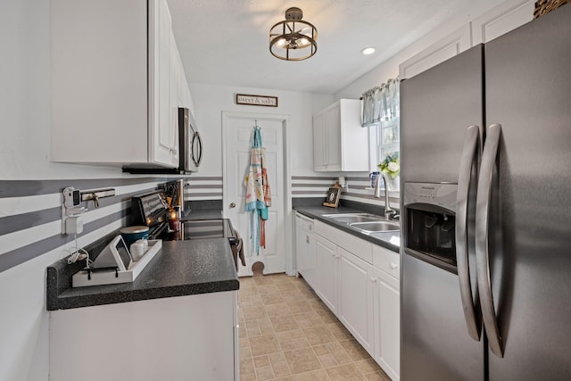 kitchen with white cabinets, appliances with stainless steel finishes, a textured ceiling, and sink