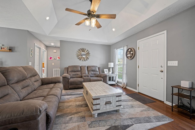 living room with ceiling fan, dark hardwood / wood-style flooring, and vaulted ceiling