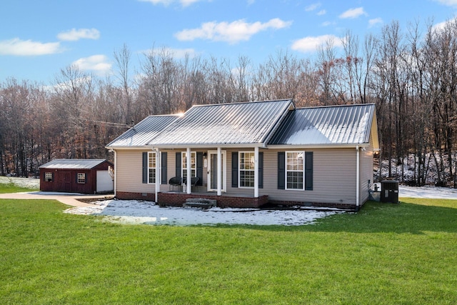 view of front facade with a garage, covered porch, a front lawn, and an outdoor structure