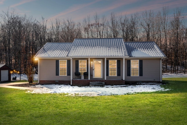 back house at dusk with covered porch and a yard