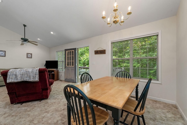 dining space featuring light carpet, lofted ceiling, and ceiling fan with notable chandelier