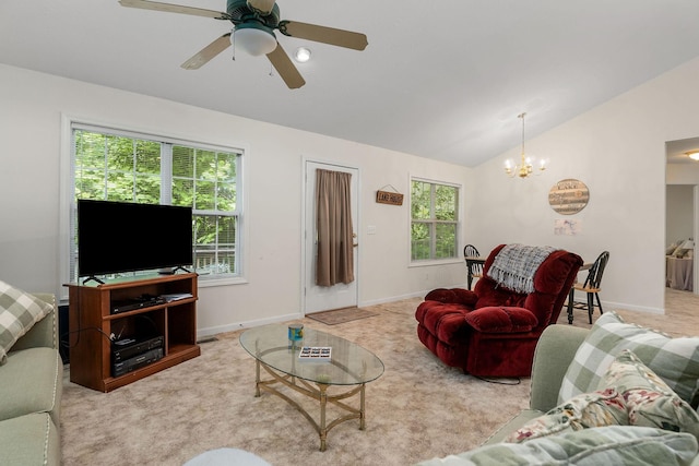 carpeted living room with a wealth of natural light, lofted ceiling, and ceiling fan with notable chandelier