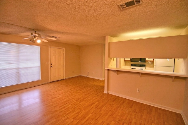 unfurnished living room with ceiling fan, wood-type flooring, and a textured ceiling