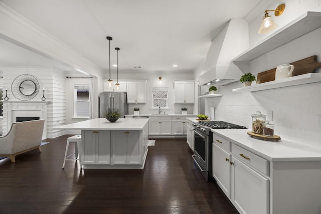 kitchen featuring a kitchen island, white cabinetry, tasteful backsplash, high end appliances, and custom range hood