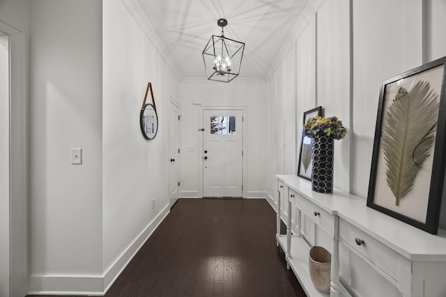 doorway with dark hardwood / wood-style floors and crown molding