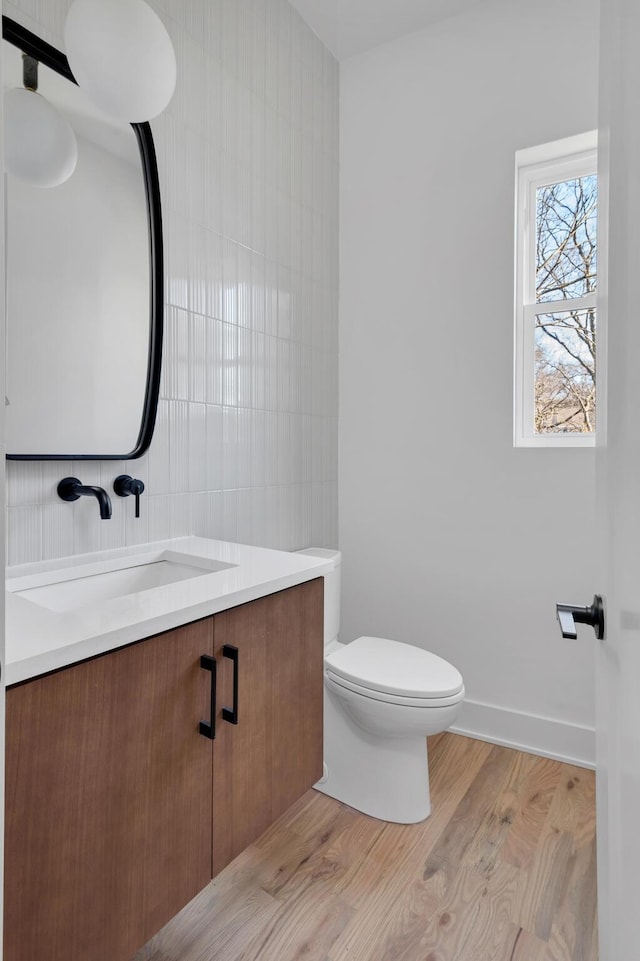 bathroom with vanity, hardwood / wood-style floors, tile walls, and toilet