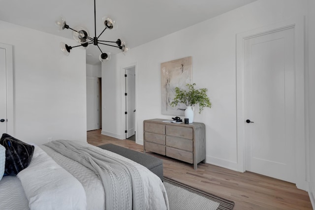 bedroom featuring a chandelier and light hardwood / wood-style floors