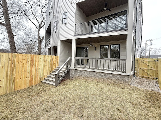 exterior space with a yard, a balcony, and ceiling fan