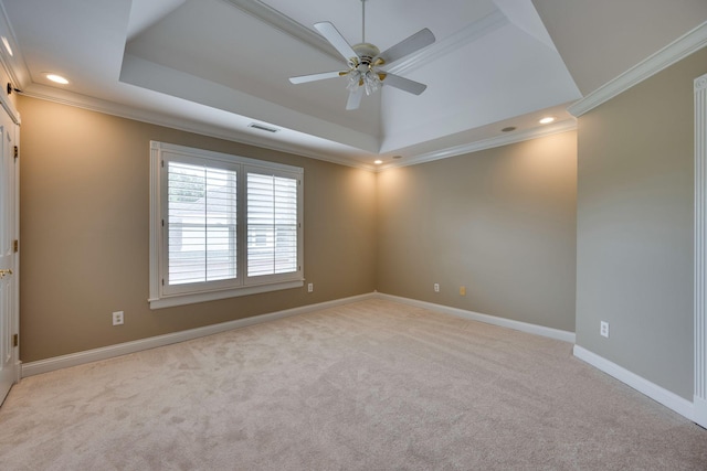 carpeted empty room with crown molding, a raised ceiling, and ceiling fan