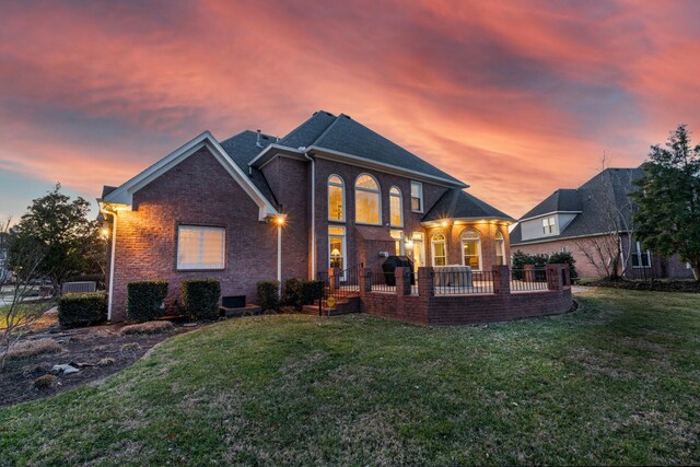 back house at dusk featuring a yard