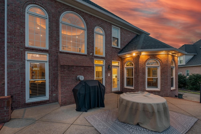 back house at dusk with a patio