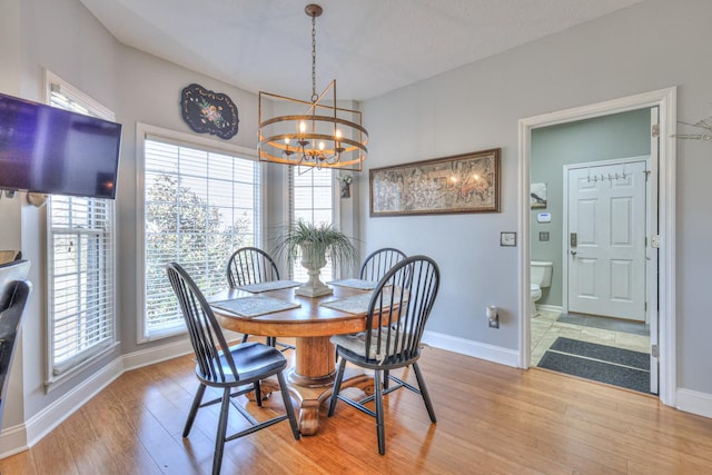 dining space featuring light wood-type flooring and an inviting chandelier